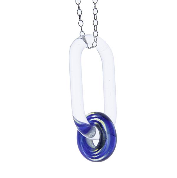 close up if clear glass link passing through swirly blue glass bead, hanging in front of a white background.