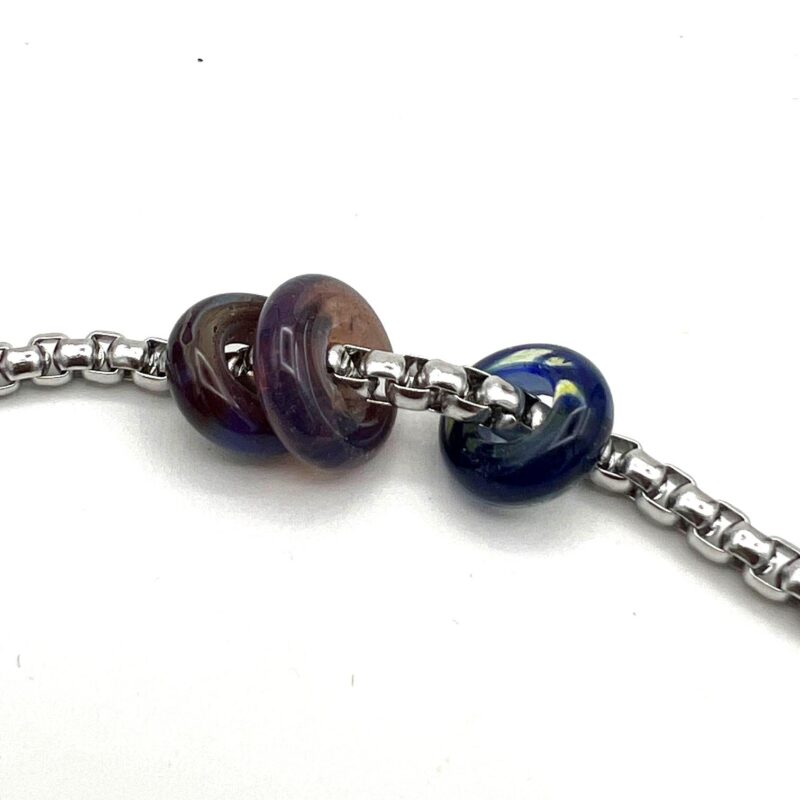 chunky stainless steel chain passes through three beads