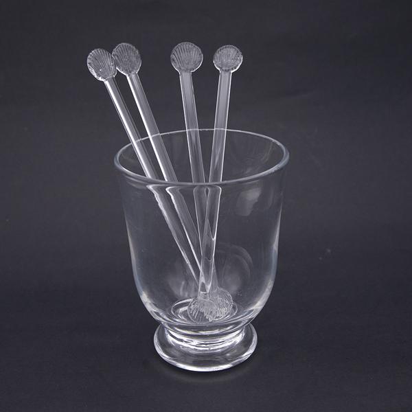 4 clear glass cocktail stirrers with sunray ends in an empty tumbler