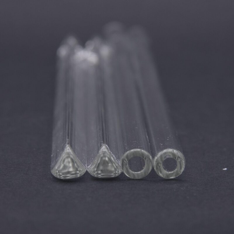 two triangle glass cocktail stirrers and two straws, photographed from the end.