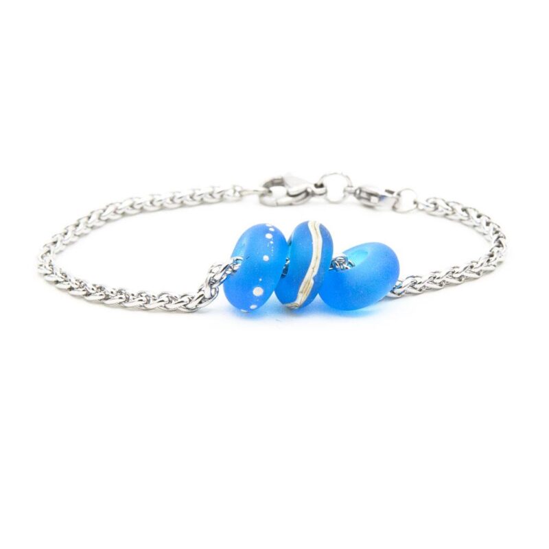 silver chain bracelet with three turquoise glass beads. The beads for a set, one decorated with silver dots, the next with a line of silvered ivory glass ivory and the last plain. All three beads have a frosted finish.