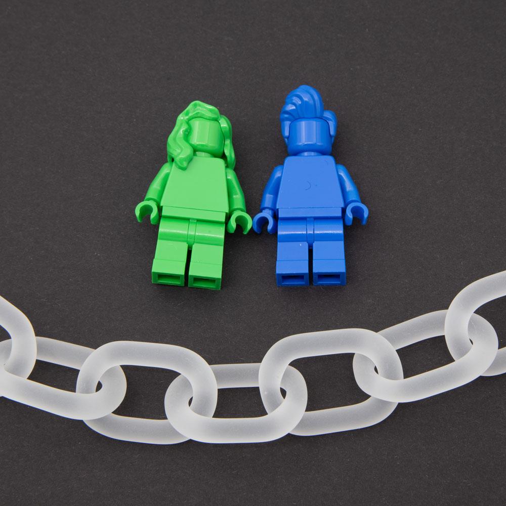 Close up of necklace made from frosted links of clear glass. The image also shows two lego figures for scale.