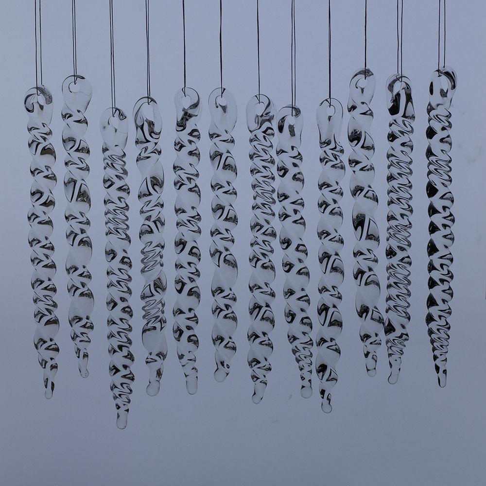 12 large clear glass icicles with hanging loop and twist design. The icicles hand in front of a frosty blue background.