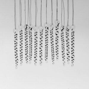 12 tiny clear glass icicles with hanging loop and twist design. The icicles hand in front of a pale grey background.