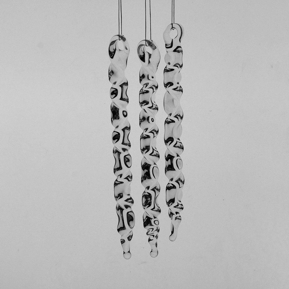 3 large clear glass icicles with hanging loop and zig zag design. The icicles hand in front of a pale grey background.