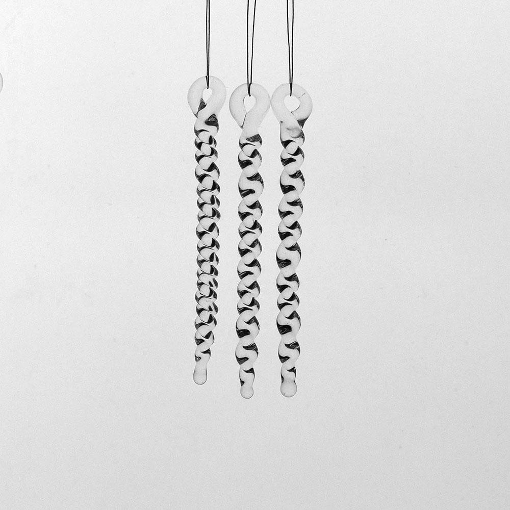 3 tiny clear glass icicles with hanging loop and twist design. The icicles hand in front of a pale grey background.