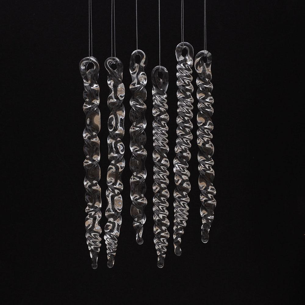 6 large clear glass icicles with hanging loop and twist or zig zag design. The icicles hand in front of a black background.