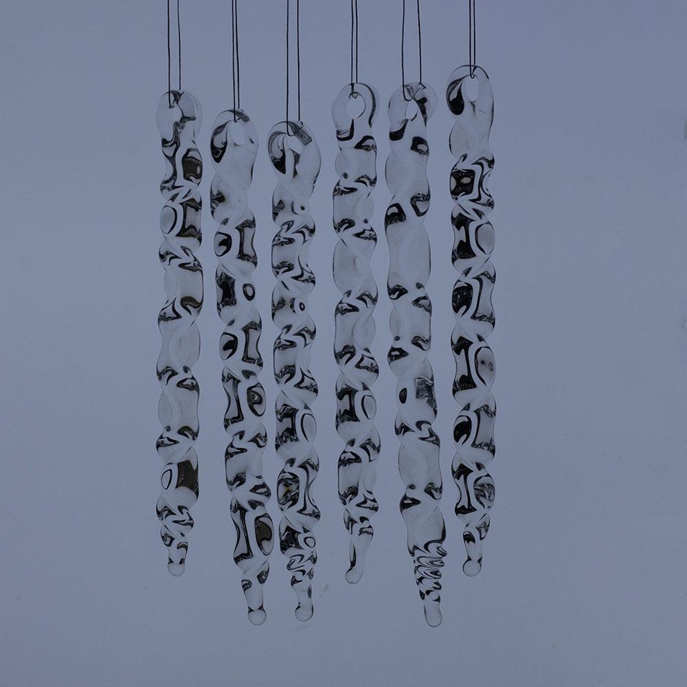 6 large clear glass icicles with hanging loop and zig zag design. The icicles hand in front of a frosty blue background.