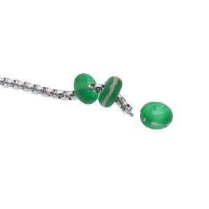 Close up of rolo belcher chain showing end finished with small ring which allows beads to be added and removed. Two green beads are on the chain, one green bead has been removed.