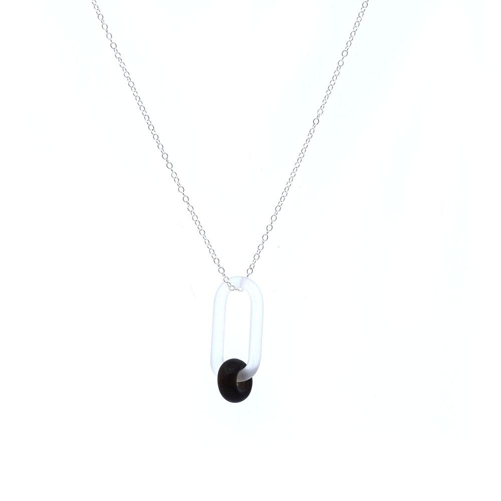 A clear glass link which passes through a bead made from the transparent dark brown glass of a beer bottle. Link and beads have a frosted finish. The link hangs from a fine sterling silver chain.