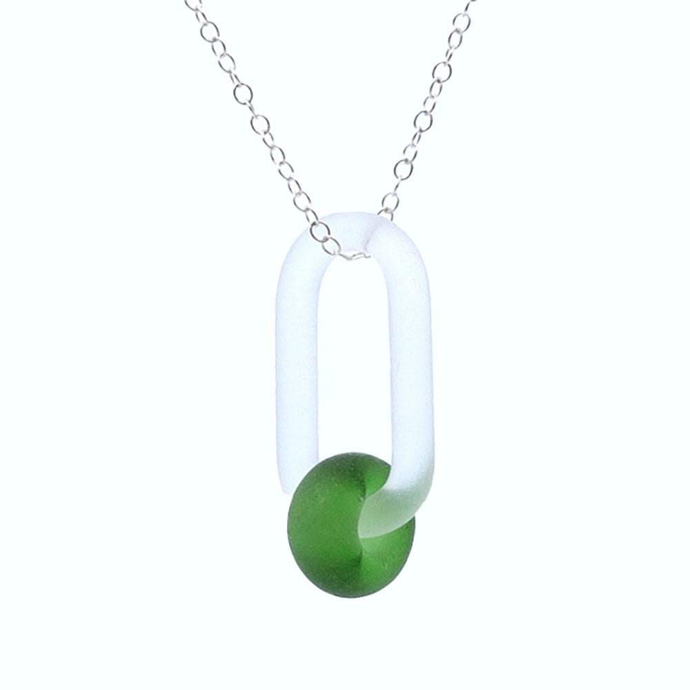 Close up view. A clear glass link which passes through a bead made from a bright green Gordons gin bottle. Link and bead have a frosted finish. The link hangs from a fine sterling silver chain.