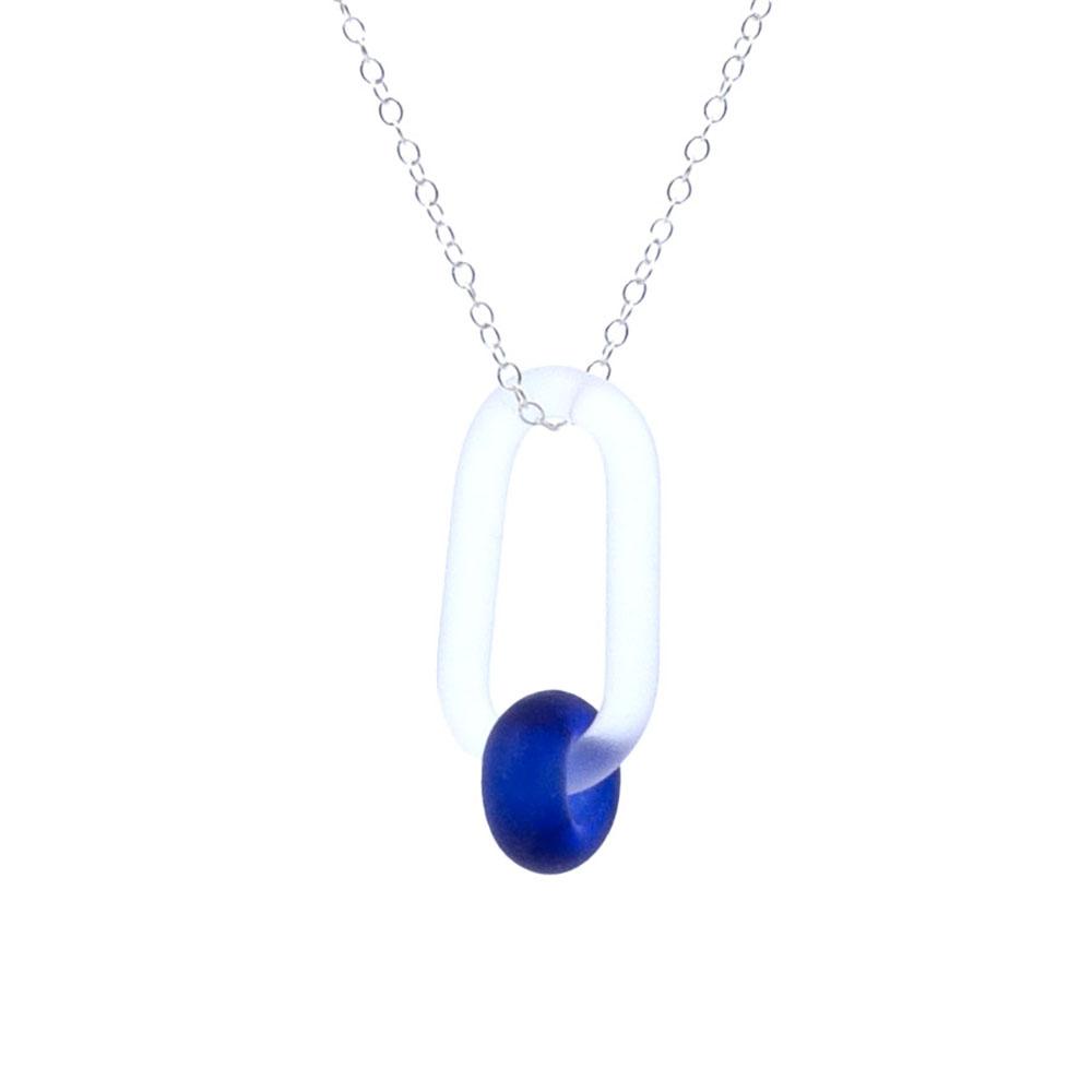 Close up view. A clear glass link which passes through a bead made from a deep blue sherry bottle. Link and bead have a frosted finish. The link hangs from a fine sterling silver chain.