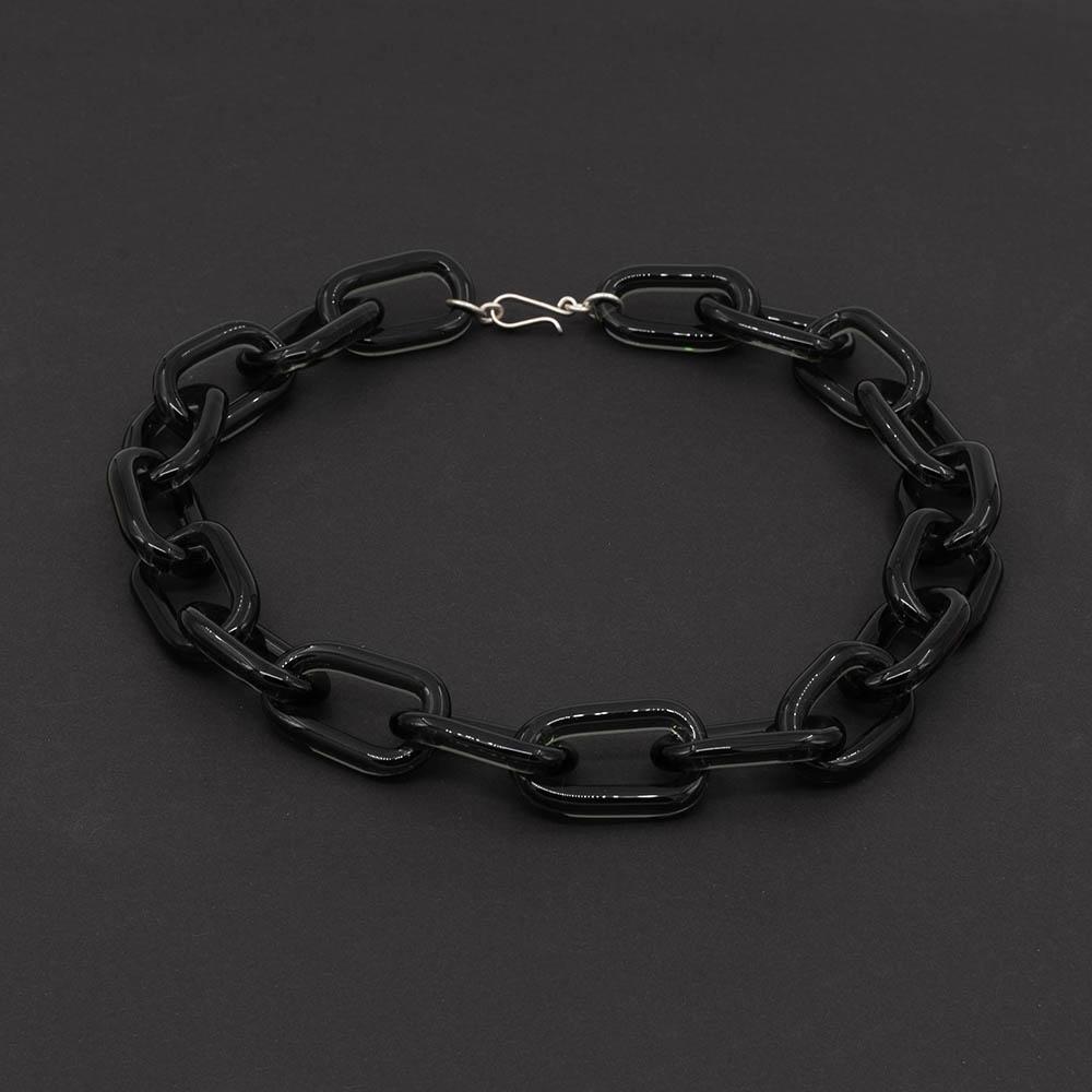 Transparent black glass chain link necklace with a sterling silver hook and loop catch. The necklace sits on a dark background.