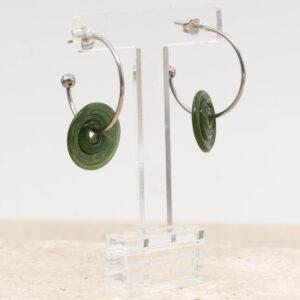 Side view of forest green glass disc hanging on a stainless steel hoop earring with a butterfly back.