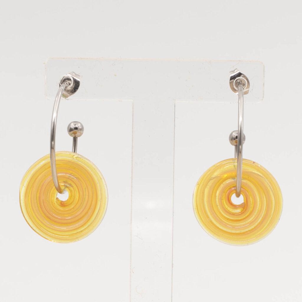 Front view of grapefruit yellow glass disc hanging on a stainless steel hoop earring with a butterfly back.