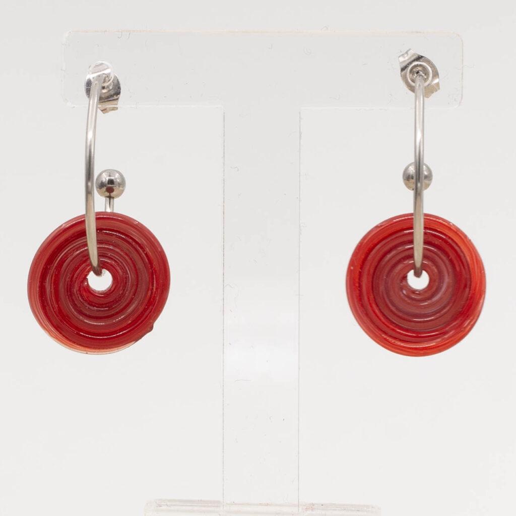 Front view of red glass disc hanging on a stainless steel hoop earring with a butterfly back.