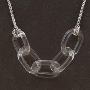 Close up of necklace with five clear glass links. The links are fastened to a chain to make a necklace. Shown on a slate background.