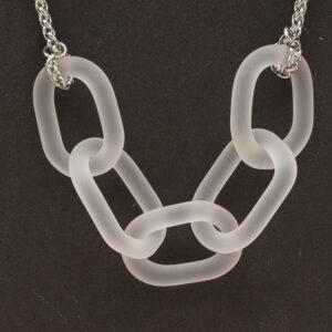 Close up of necklace with five frosted clear glass links. The links are fastened to a chain to make a necklace. Shown on a slate background.