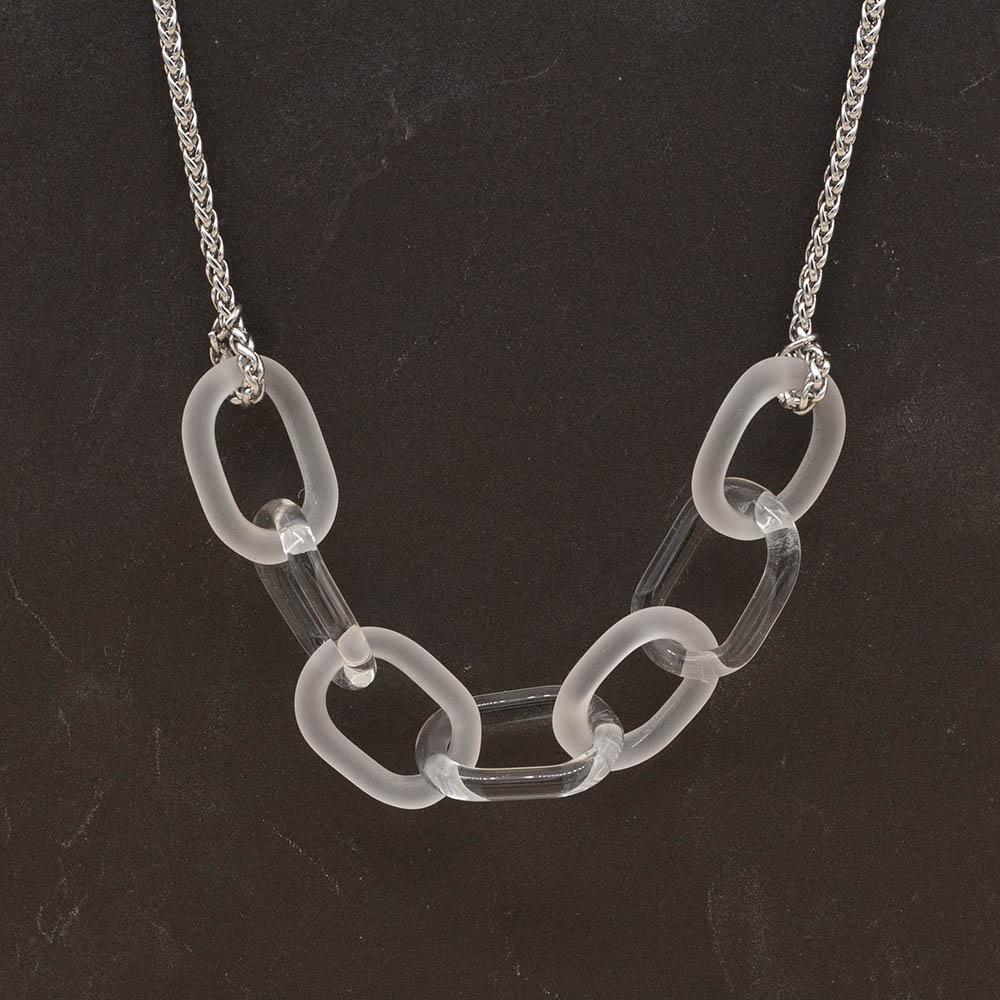 Necklace with seven alternating frosted and clear glass links. The links are fastened to a chain to make a necklace. Shown on a slate background.