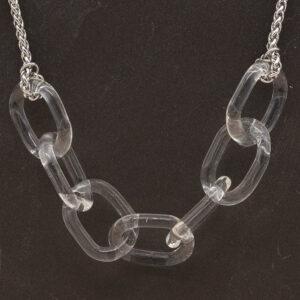 Close up of necklace with seven clear glass links. The links are fastened to a chain to make a necklace. Shown on a slate background.