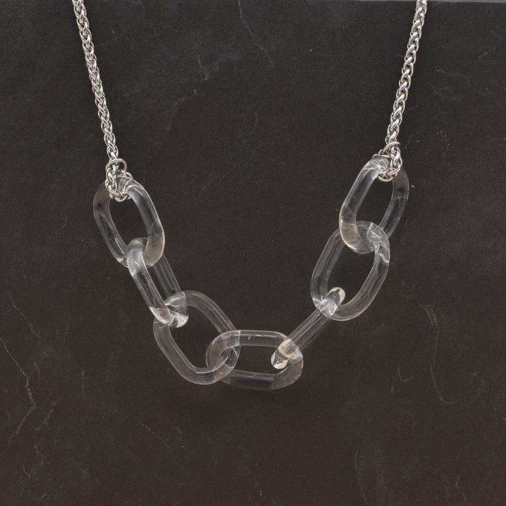 Necklace with seven clear glass links. The links are fastened to a chain to make a necklace. Shown on a slate background.