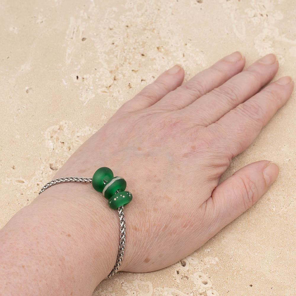 3 frosted green glass beads with big holes on a stainless steel chain bracelet, shown worn on a wrist.