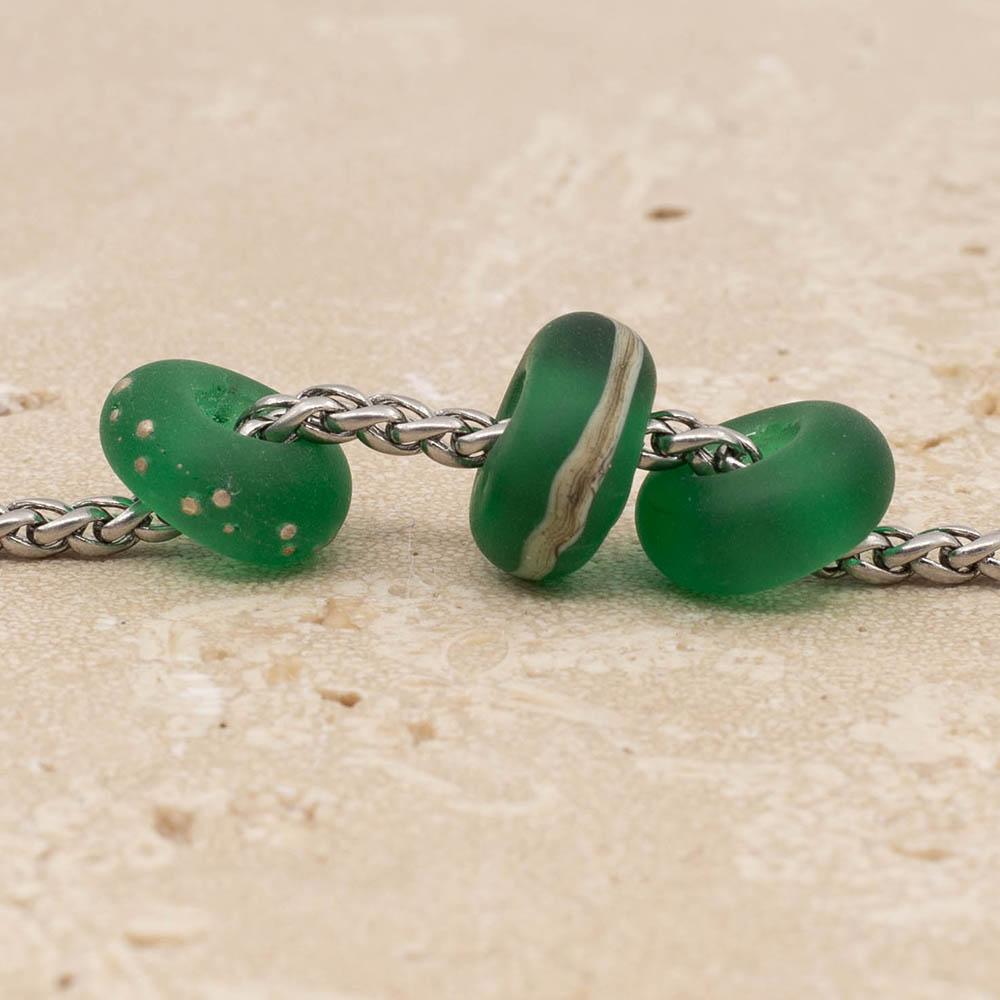 Close up of 3 frosted green glass beads with big holes on a stainless steel chain.