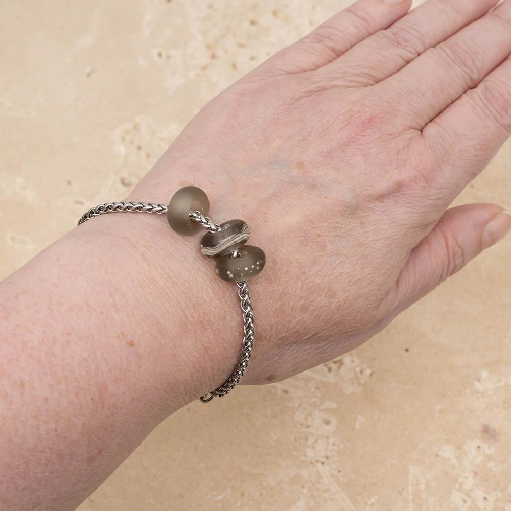 3 frosted grey glass beads with big holes on a stainless steel chain. bracelet shown worn on a wrist