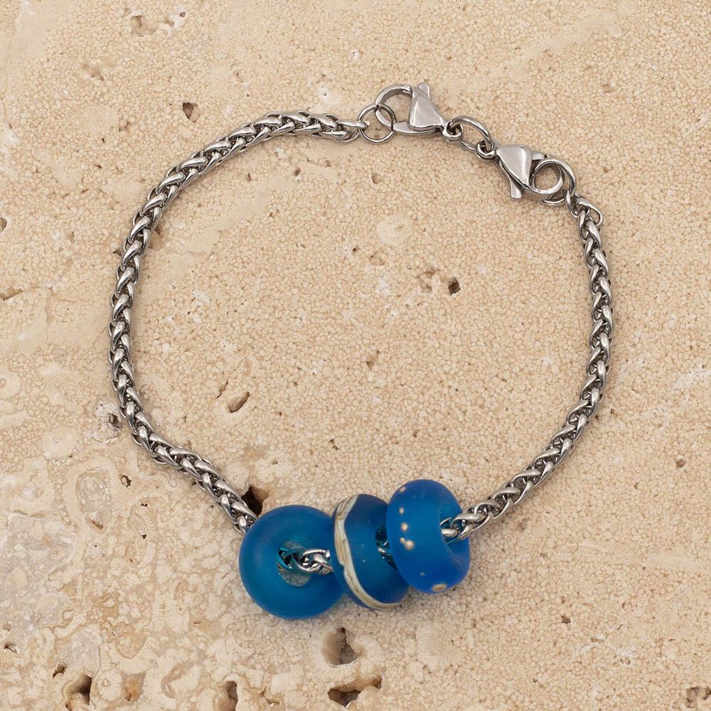 3 decorated frosted turquoise glass beads with big holes on a stainless steel bracelet with double lobster clasps.