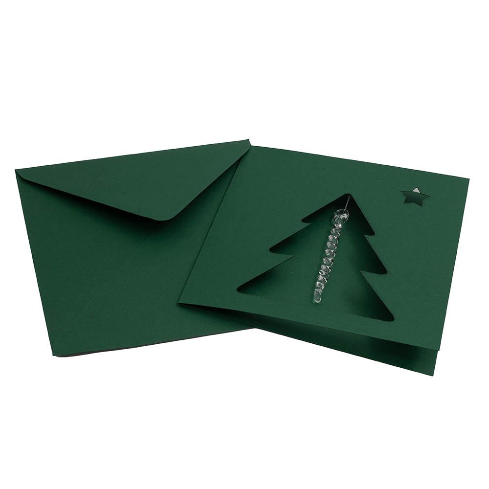 Dark green greetings card and envelope. The card is square. The card has a cutout of a Christmas tree and small star. A clear glass icicle hangs from the top of the tree.
