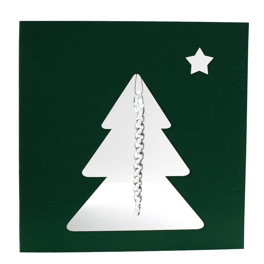 Front of dark green greetings card. The card is square. The card has a cutout of a Christmas tree and small star. A clear glass icicle hangs from the top of the tree.
