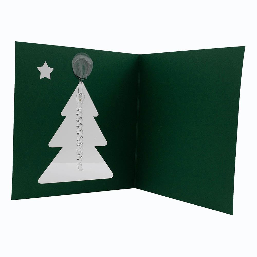 Inside of dark green greetings card. The card is square. The card has a cutout of a Christmas tree and small star. A clear glass icicle hangs from the top of the tree. The thread holding the icicle is held in place with sellotape dot.